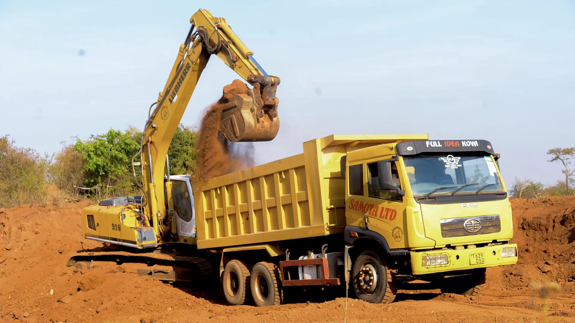 An excavator loads laterite road material sourced from within the mining licence for use in the access road repairs.